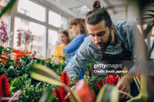 un empleado de floristería y un joven huésped - flower shop fotografías e imágenes de stock