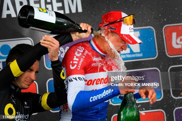 Second-placed France's Anthony Turgis of Direct Energie pours Champagne on winner Netherland's Mathieu Van der Poel on the podium of the 74th edition...