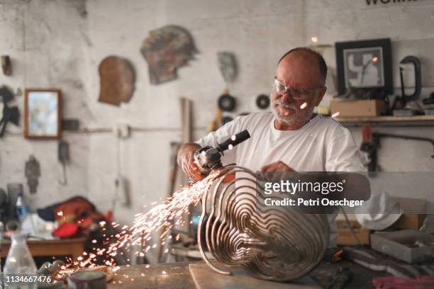 ein senior mann schafft skulpturen in seinem atelier - skulptur kunsthandwerkliches erzeugnis stock-fotos und bilder