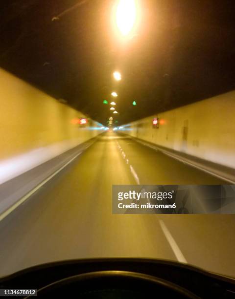 night motion blur shot of a car driving fast in a tunnel - fast motion stock pictures, royalty-free photos & images