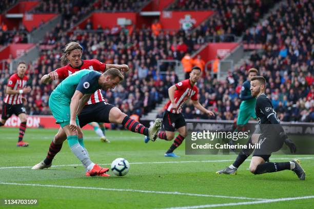 Harry Kane of Tottenham Hotspur scores his team's first goal past Angus Gunn of Southampton during the Premier League match between Southampton FC...