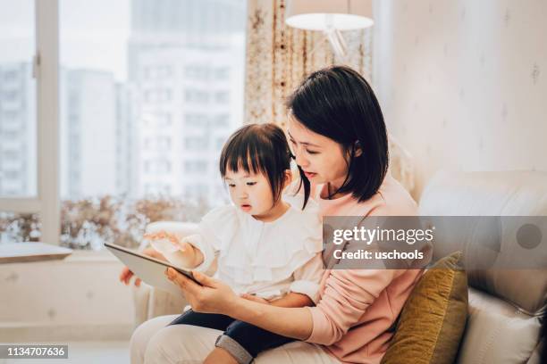 chinese moeder en dochter met behulp van digitale tablet - chinese kid stockfoto's en -beelden