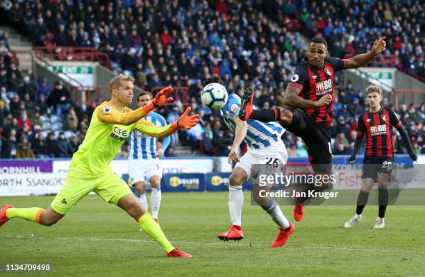 Callum Wilson of AFC Bournemouth chases Jonas Lossl of Huddersfield Town for the ball during the Premier League match between Huddersfield Town and...
