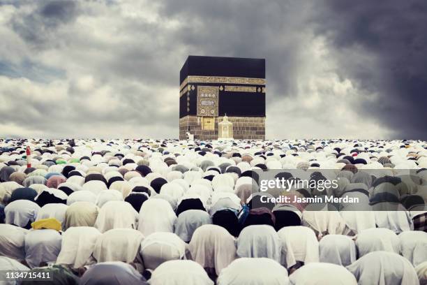 crowded people gathering for praying with dramatic sky - makkah mosque stock-fotos und bilder