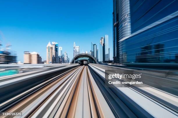 metro riding through downtown dubai - dubai metro stock-fotos und bilder