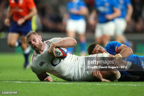 George Kruis of England scores his team's sixth try whilst being tackled by Tommaso Allan of Italy during the Guinness Six Nations match between...
