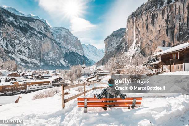 man admiring lauterbrunnen in winter, switzerland - behind waterfall stock-fotos und bilder