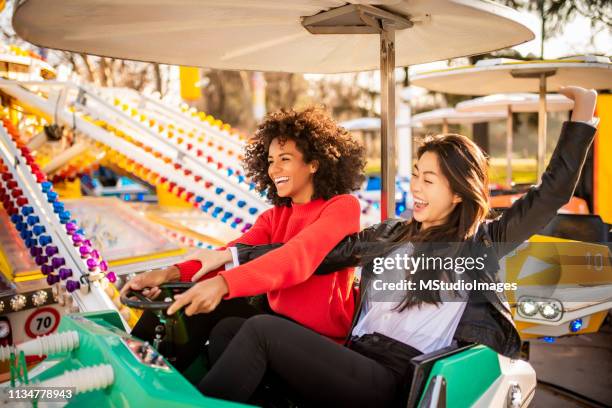 two friends riding amusement park ride - joy ride stock pictures, royalty-free photos & images