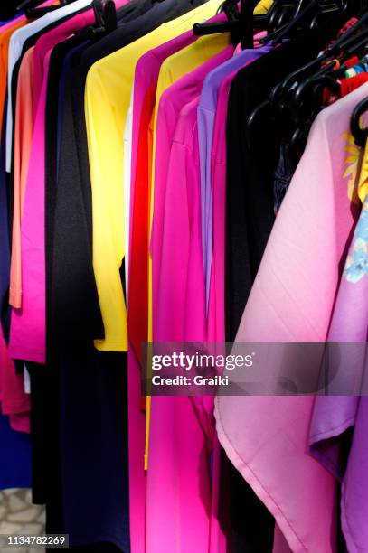 colourful clothes in wardrobe - hanging clothes stock-fotos und bilder
