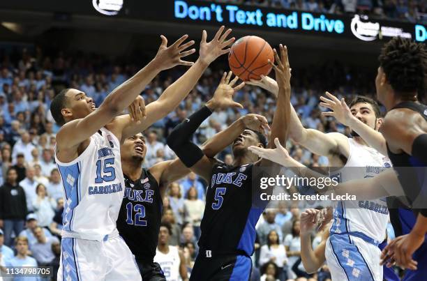 Teammates Javin DeLaurier and RJ Barrett of the Duke Blue Devils battle for a loose ball against Garrison Brooks and Luke Maye of the North Carolina...