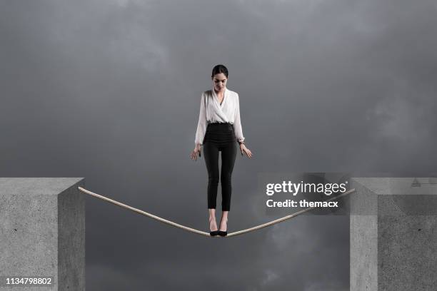 businesswoman standing looking down on a rope - woman tightrope stock pictures, royalty-free photos & images
