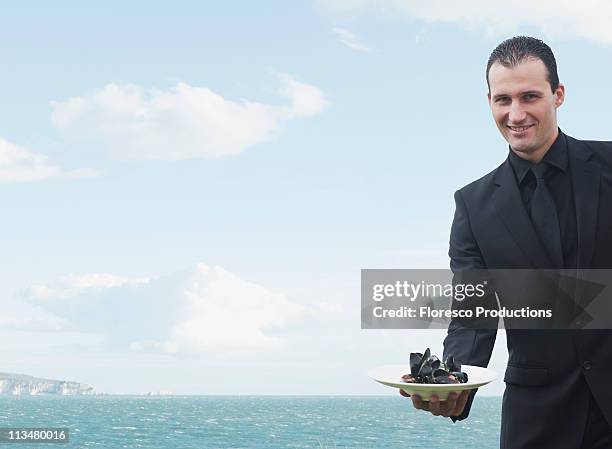 man smiling to camera - blue plate stock pictures, royalty-free photos & images