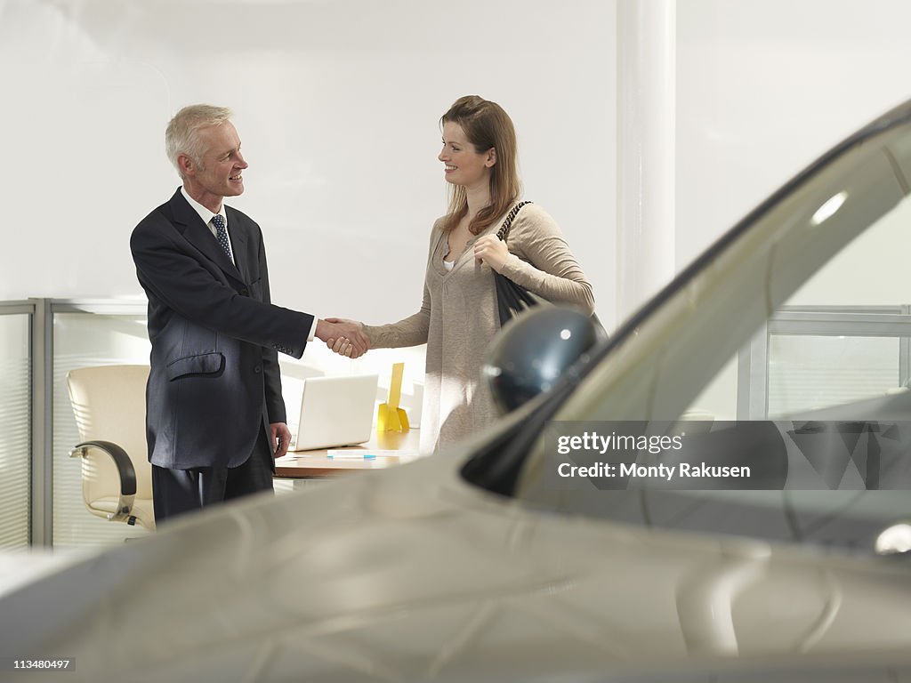 Salesman and customer in car dealership
