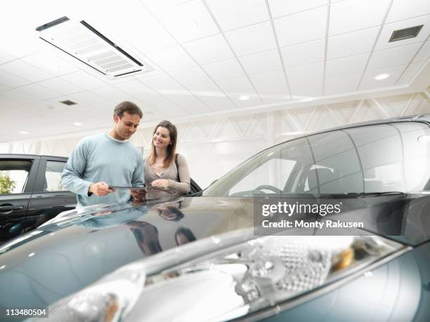 customers look at car in car dealership - new boyfriend stock pictures, royalty-free photos & images