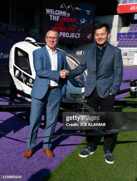 Derrick Xiong , co-founder & CMO of EHang, and Robert Machtlinger, CEO of FACC, shake hands as they pose with an Air Taxi EHANG 216 during a press...