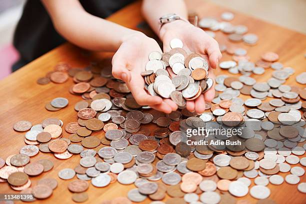 girl holding coins in her hands - uk cash stock pictures, royalty-free photos & images