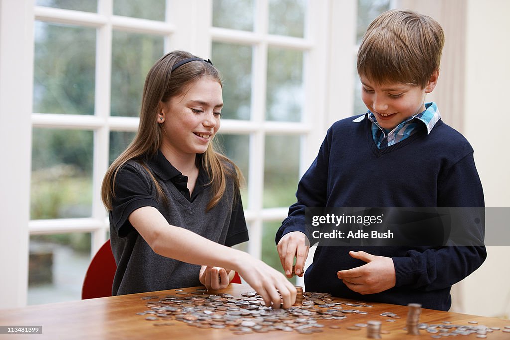 Niños recuento montones de monedas
