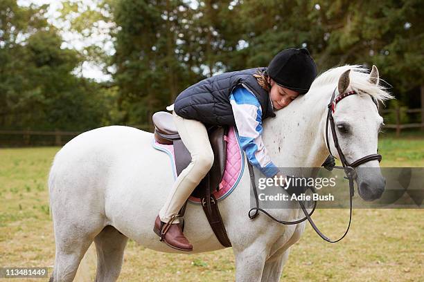 girl cuddling her pony - ponies stock-fotos und bilder