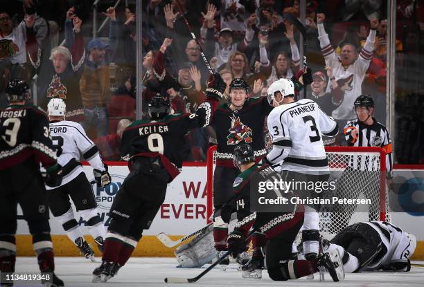 Christian Dvorak of the Arizona Coyotes celebrates with Clayton Keller after scoring a goal ahead of Dion Phaneuf and Trevor Lewis of the Los Angeles...