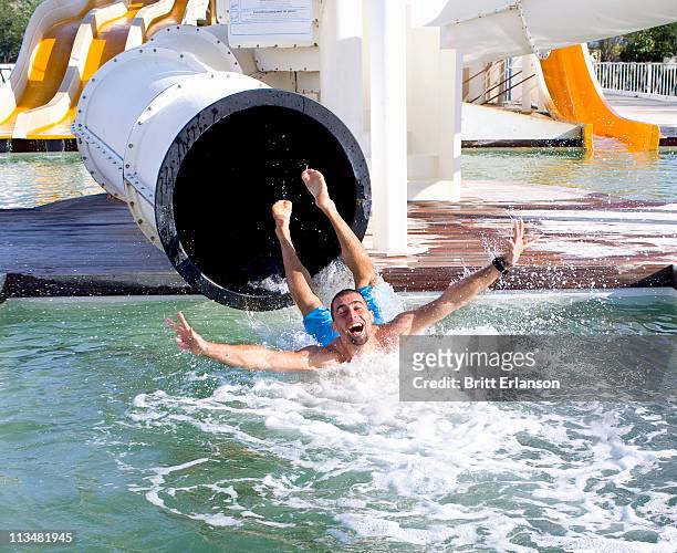 young man falls into pool from slide - waterslide bildbanksfoton och bilder