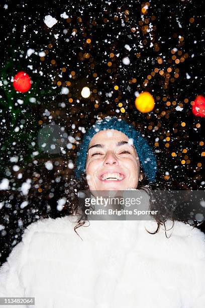 woman standing in snowfall - munich winter stock pictures, royalty-free photos & images