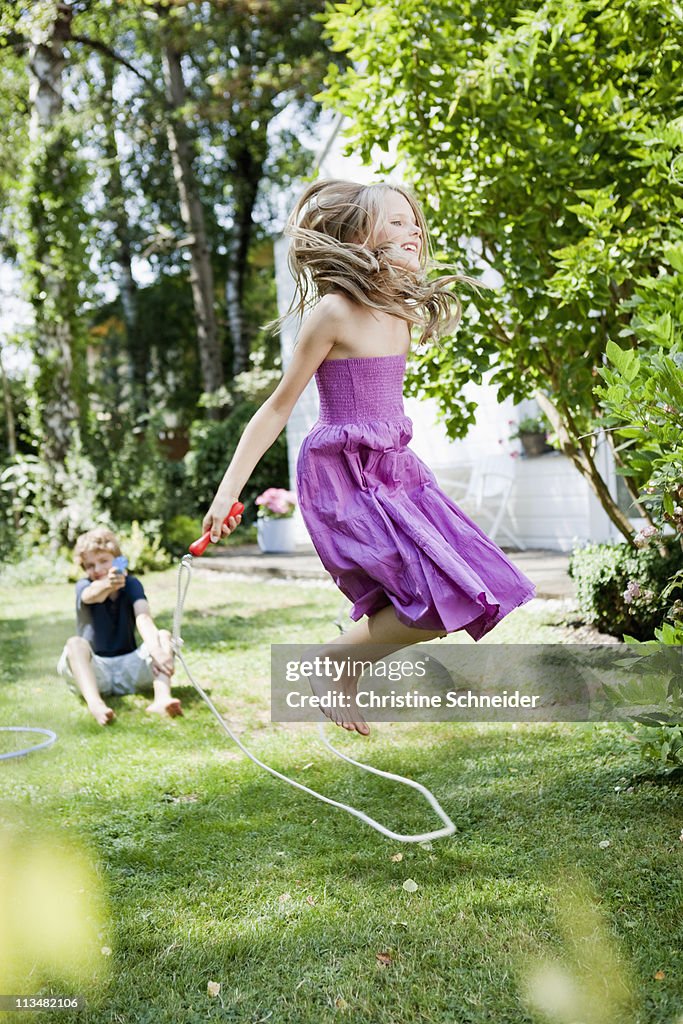 Girl jumping rope in garden