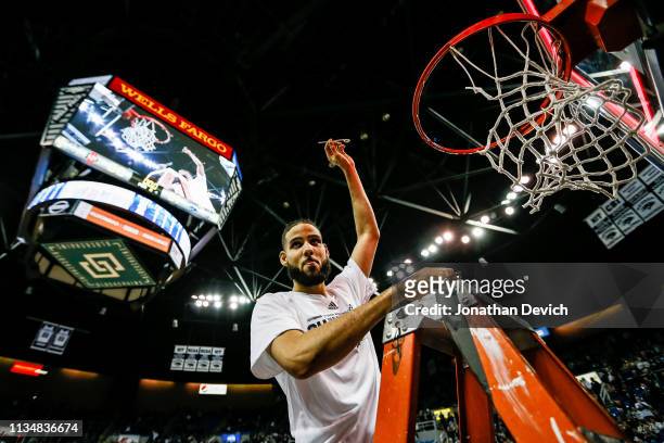 Caleb Martin of the Nevada Wolf Pack holds up a piece of the net that he cut off after winning the Mountain West Championships after beating the San...