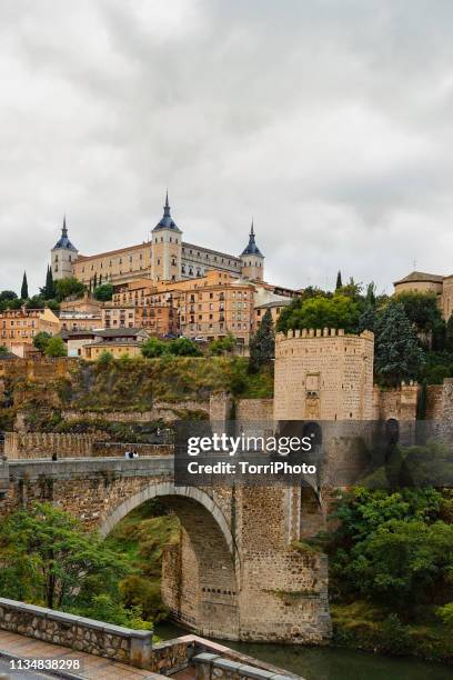 cityscape of old spain town toledo with alcazar castle and alcantara bridge - koninklijk paleis van sevilla stockfoto's en -beelden