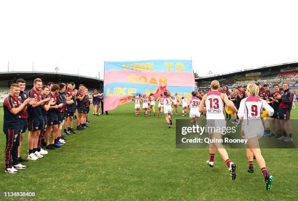 The Brisbane Lions men's players form a guard of honour as the Women's team run out onto the ground during the round six AFLW match between the...