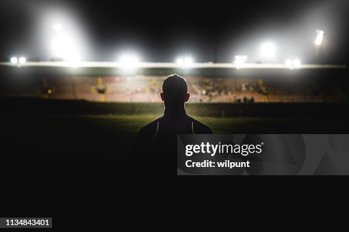 Athlete walking towards stadium silhouette Athlete walking towards stadium silhouette