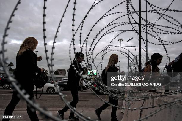 People queue at the San Ysidro crossing port to cross from Tijuana in Mexico to San Diego in the US on April 4, 2019. - US President Donald Trump's...