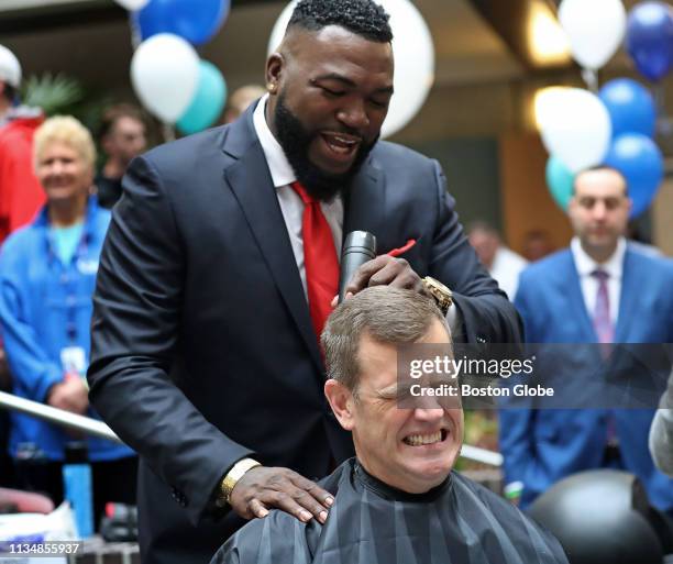 Former Boston Red Sox player David Ortiz shaves the head of Red Sox president Sam Kennedy during Granite Telecommunications sixth annual Saving by...