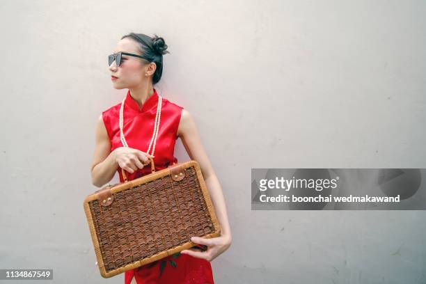 chinese girl carrying clothes bag - the cheongsam stock-fotos und bilder