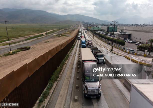 Aerial view of cargo trucks lining up to cross to the United States near the US-Mexico border at Otay Mesa crossing port in Tijuana, Baja California...