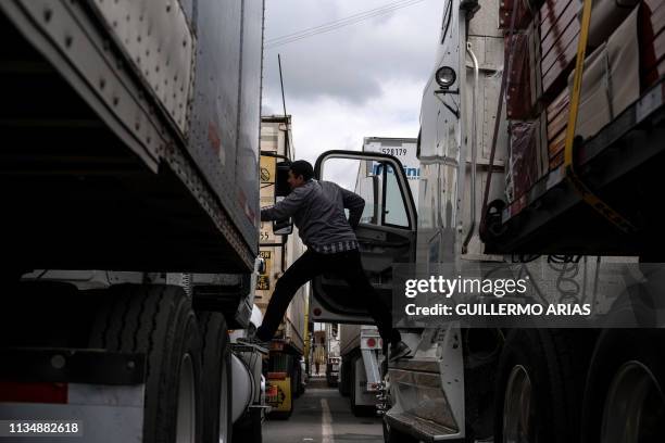 Cargo truck driver talks to a fellow driver, while lining up to cross to the United States near the US-Mexico border at Otay Mesa crossing port in...