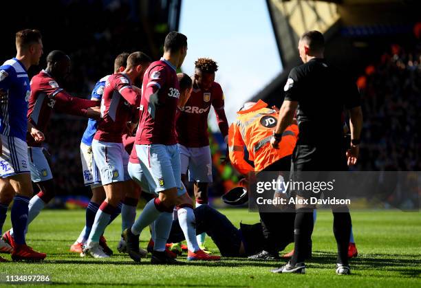 Pitch invader is tackled by a steward after striking Jack Grealish of Aston Villa during the Sky Bet Championship match between Birmingham City and...