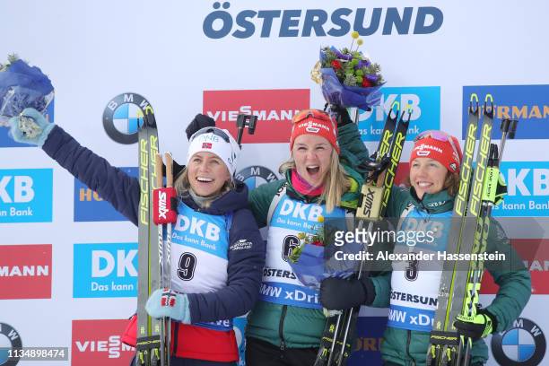 Denise Herrmann of Germany celebrates winning the gold medal ahead of Tiril Eckhoff of Norway and Laura Dahlmeier of Germany during the flower...