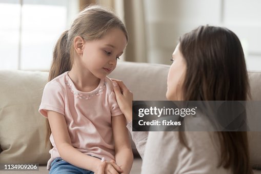 Loving mom talking to upset little child girl giving support Loving mom talking to upset little child girl giving support