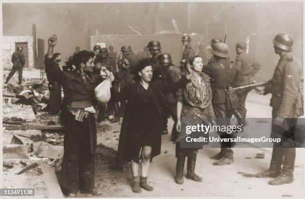 German Nazi SS troops guarding members of the Jewish resistance captured during the suppression of the Warsaw ghetto uprising in 1943. About 13,000...