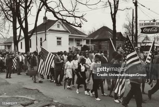 Participants, some carrying American flags, marching in the Civil Tights march from Selma to Montgomery, Alabama, USA, in 1965. Photographer: Peter...