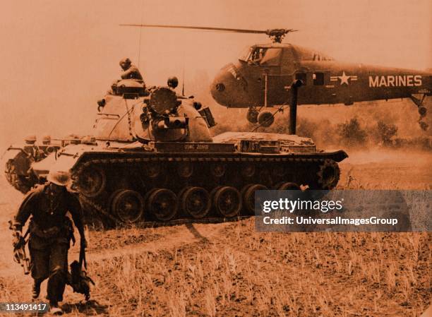 Helicopter evacuates STARLITE casualties, while a Marine M-48 tank stands guard. The Marine on the left carries a M-79 grenade launcher.