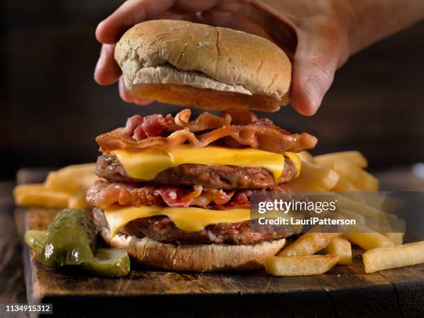 bacon dubbele cheeseburger met frietjes - bacon cheeseburger stockfoto's en -beelden