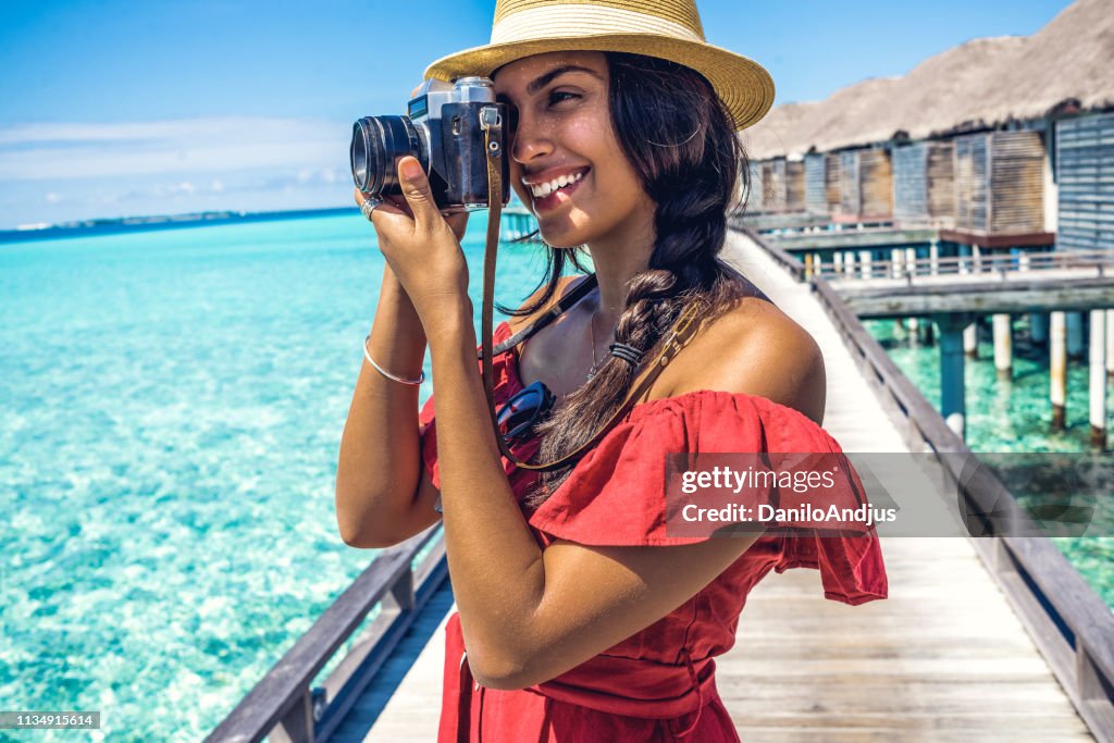 Mujer joven disfrutando de sus vacaciones y fotografiando
