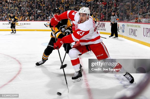 Dominic Turgeon of the Detroit Red Wings handles the puck against Justin Schultz of the Pittsburgh Penguins at PPG Paints Arena on April 4, 2019 in...