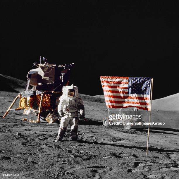 Harrison H Schmitt, pilot of the lunar module, stands on the lunar surface near the United States flag during NASA's final lunar landing mission in...