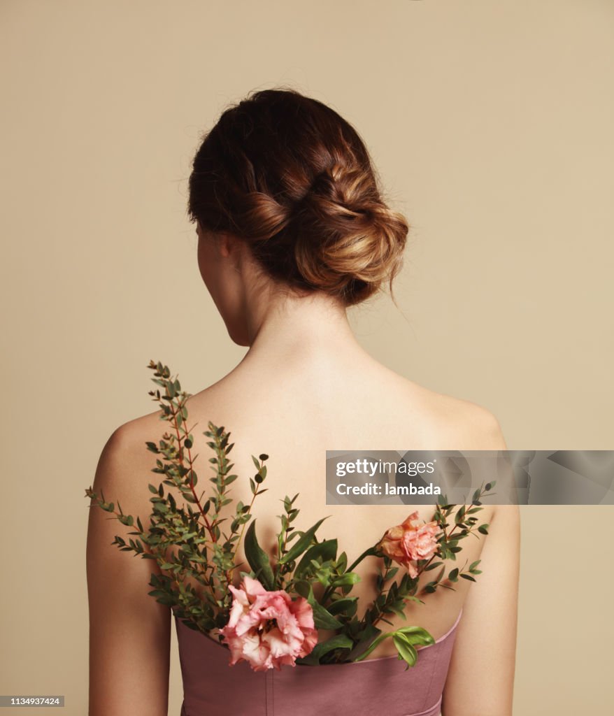 Vista posterior de la mujer joven y las flores