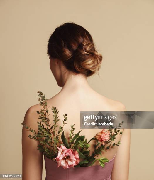 rear view of young woman and flowers - hair bun back stock pictures, royalty-free photos & images