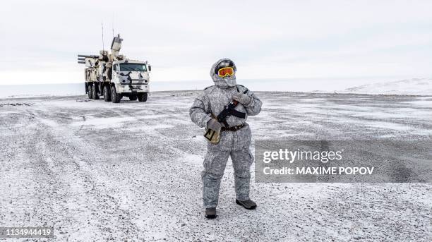 Soldier holds a machine gun as he patrols the Russian northern military base on Kotelny island, beyond the Artic circle on April 3, 2019. - The...