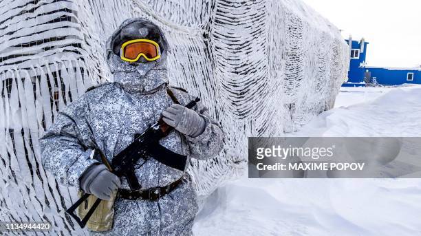 Soldier holds a machine gun as he patrols the Russian northern military base on Kotelny island, beyond the Artic circle on April 3, 2019. The Russian...