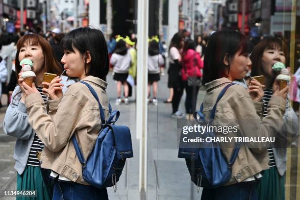 People eat ice cream in Tokyo's Harajuku district on April 5, 2019.